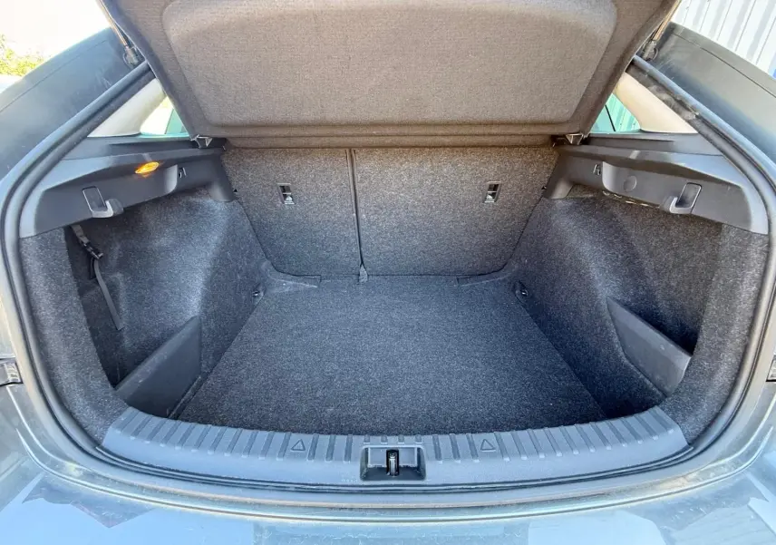 Coffre ouvert vu de l'arrière d'une Skoda Scala gris graphite 2025, montrant un espace de chargement propre et spacieux.