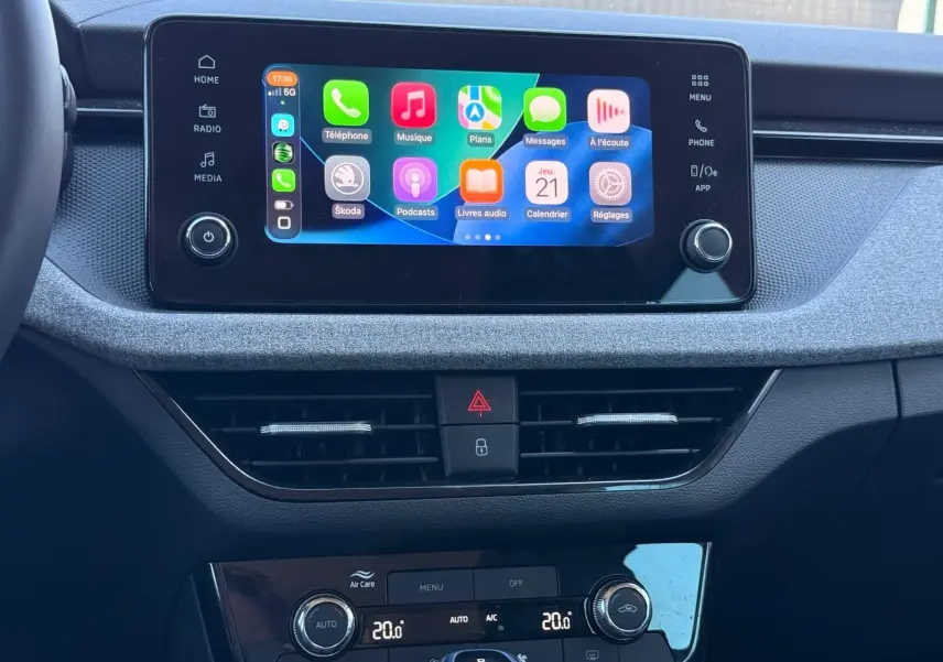 Intérieur de la Skoda Scala 2025 en gris graphite, vue sur l’écran tactile central et la console de climatisation.