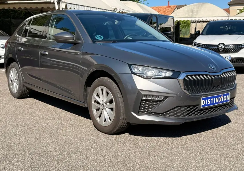 Vue 3/4 avant droite d'une Skoda Scala gris graphite 2025 avec calandre noire et jantes argentées.