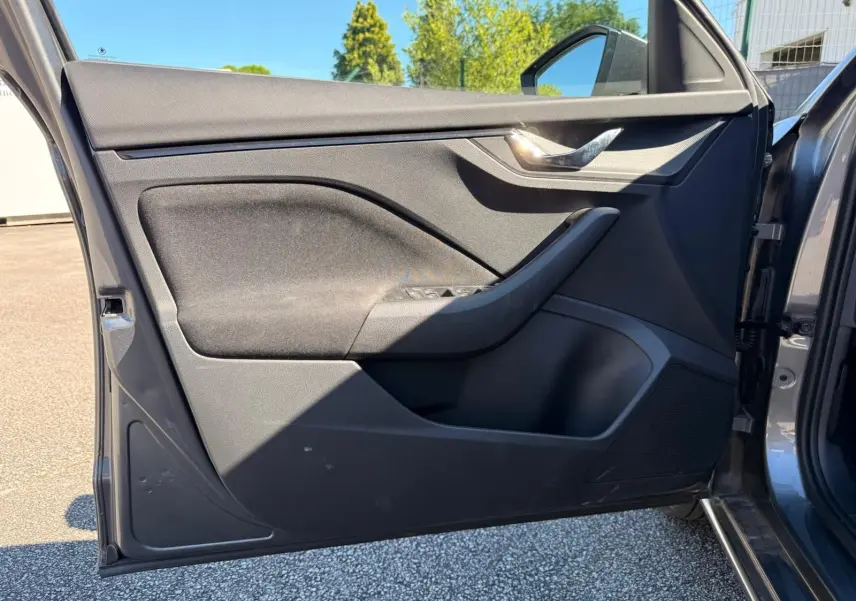 Vue rapprochée de la porte avant gauche gris graphite d’une Skoda Scala 2025, avec poignée chromée et commandes de vitres.