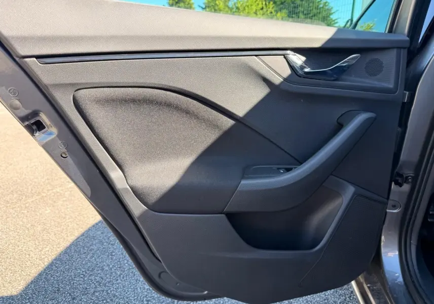 Vue de profil intérieur de la porte arrière gauche gris graphite du Skoda Scala 2025 avec poignée et haut-parleur intégrés.