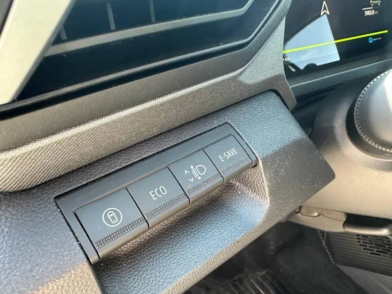 Gros plan sur les boutons de commande Eco, E-Save et phares dans l'habitacle gris du Dacia Bigster 2025.