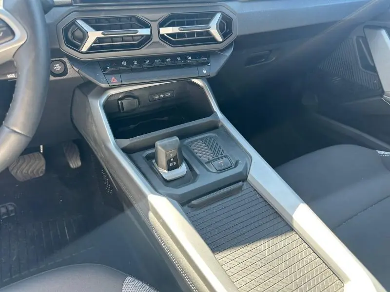 Vue intérieure centrée sur la console centrale et levier de vitesse de la Dacia Bigster gris schiste, avec aérateurs hexagonaux.