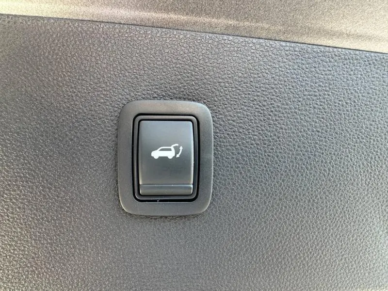 Bouton d'ouverture électrique du coffre sur panneau intérieur noir du Dacia Bigster gris Schiste 2025.
