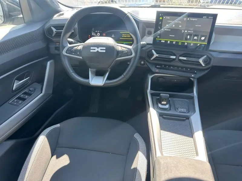 Vue intérieure avant centrée sur le volant multifonction et l'écran tactile du tableau de bord du Dacia Bigster 2025.