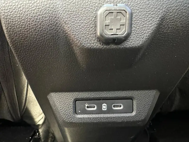 Prise USB arrière double en gros plan sur console centrale noire du Dacia Bigster gris Schiste 2025 hybride.