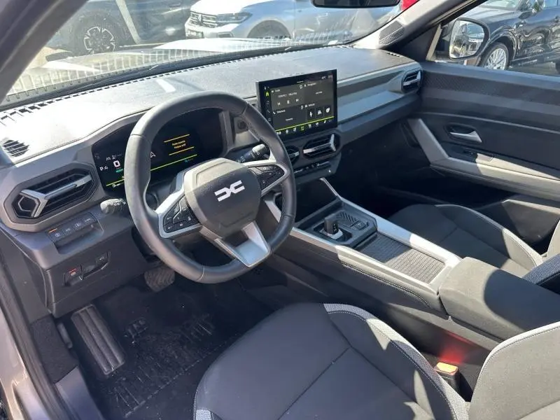 Vue intérieure côté conducteur du Dacia Bigster gris schiste 2025, avec tableau de bord numérique et écran tactile central.