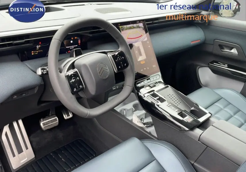 Vue intérieure côté conducteur du Citroën C5 Aircross 2026, tableau de bord gris noir avec écran tactile vertical et sièges cuir bleu clair.