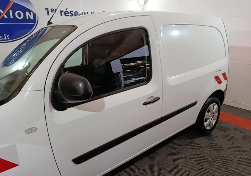 Vue de profil droit du Renault Kangoo Extra R-Link blanc avec marquages rouges sur la porte arrière.