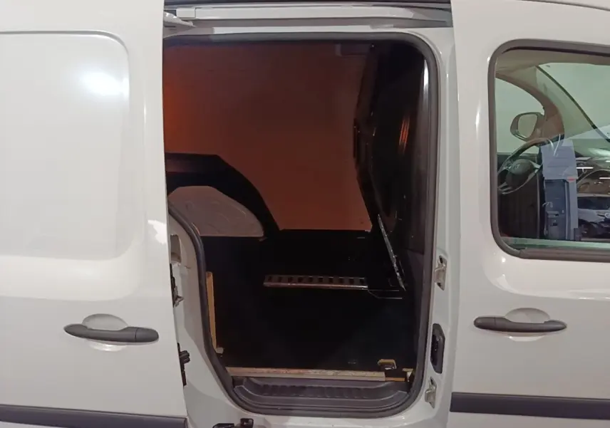 Vue latérale gauche d’un Renault Kangoo blanc 2020 avec porte coulissante ouverte montrant l’espace de chargement vide.
