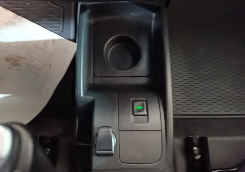 Gros plan sur la console centrale noire du Renault Kangoo blanc, avec bouton ECO éclairé en vert.