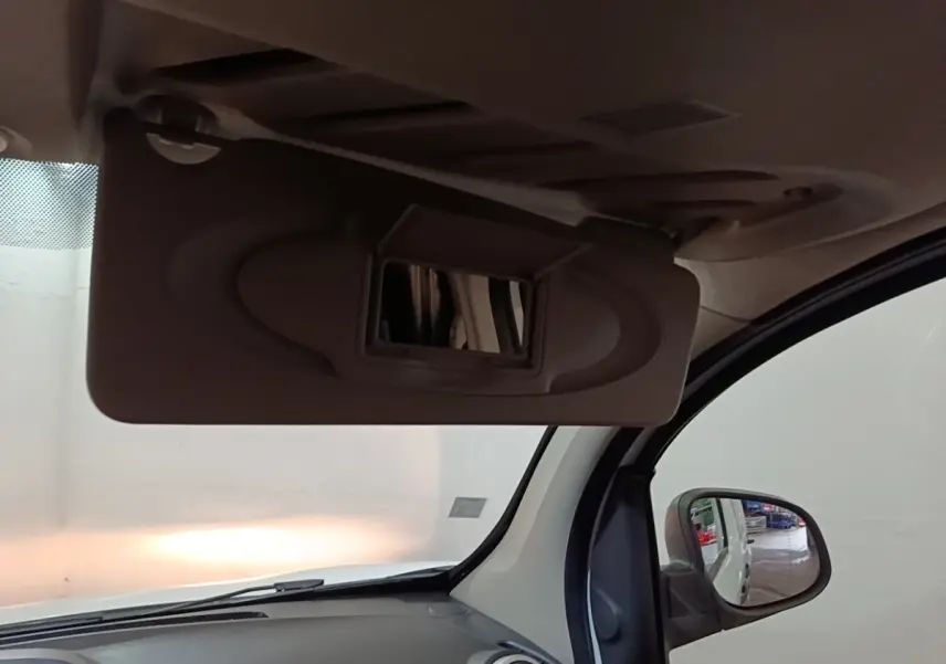 Vue intérieure du pare-soleil avec miroir ouvert côté conducteur du Renault Kangoo blanc, reflet du rétro extérieur visible.