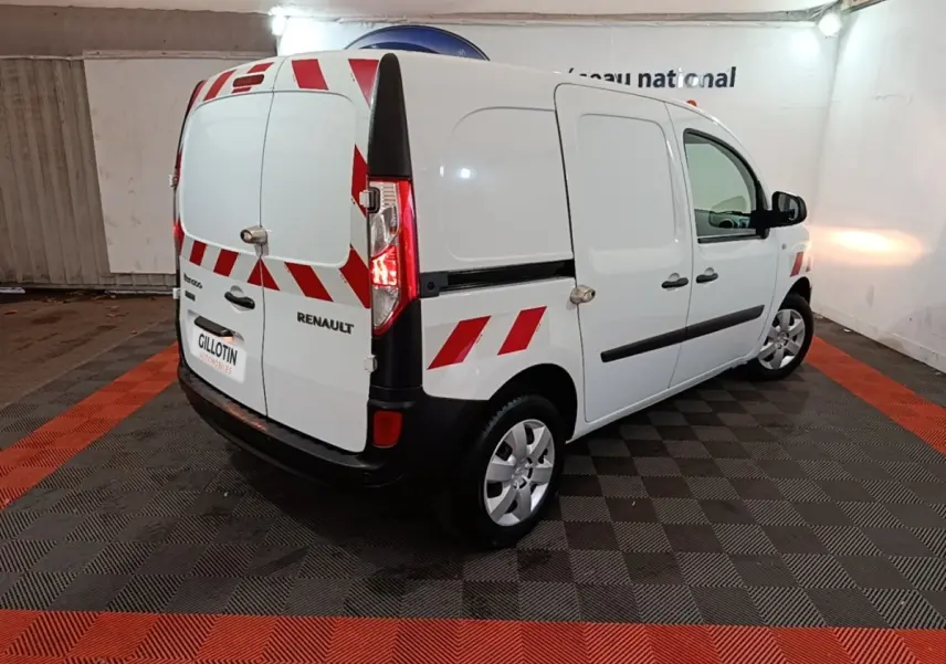 Renault Kangoo blanc vue 3/4 arrière droit avec bandes rouges réfléchissantes et porte latérale pleine.