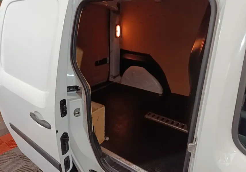 Vue intérieure côté droit du Renault Kangoo blanc 2020, montrant l’espace de chargement vide avec cloison pleine.
