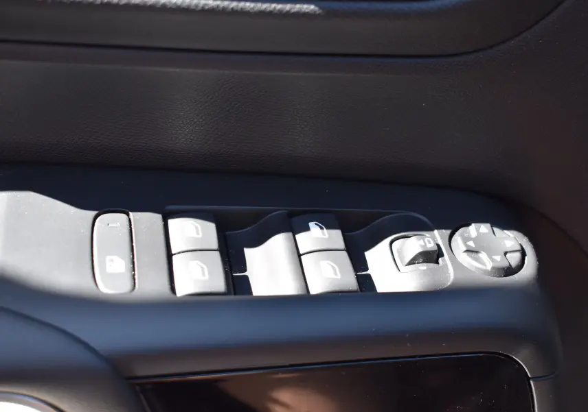 Gros plan sur les commandes des vitres et rétroviseurs côté gauche d’un Citroën C5 Aircross 2024 avec intérieur noir.
