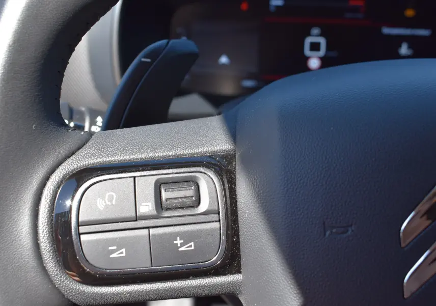 Gros plan sur les commandes du volant du Citroën C5 Aircross 2024, finition BlueHDi avec cuir noir texturé.