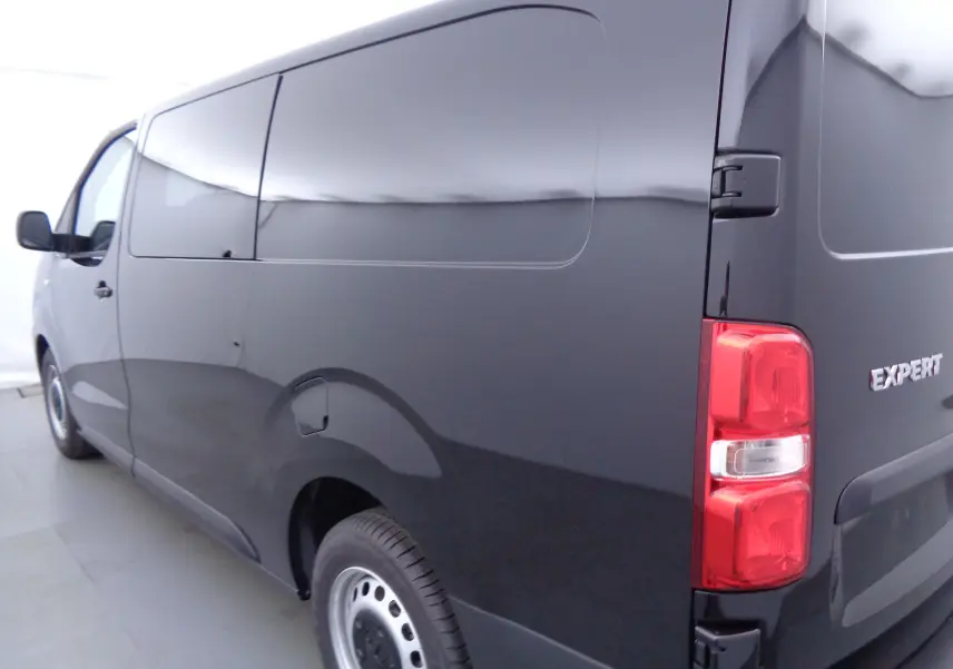 Vue 3/4 arrière droite d'un Peugeot Expert Cabine Approfondie noir perle métal, fourgon utilitaire sans vitres latérales.