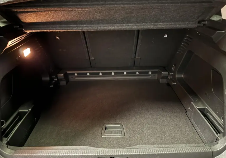 Coffre spacieux ouvert du Citroën C5 Aircross noir, montrant le plancher plat et les rangements latéraux intégrés.