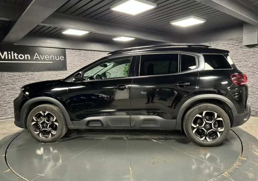 Profil côté gauche du Citroën C5 Aircross noir nacré avec jantes bi-ton et barres de toit noir brillant.
