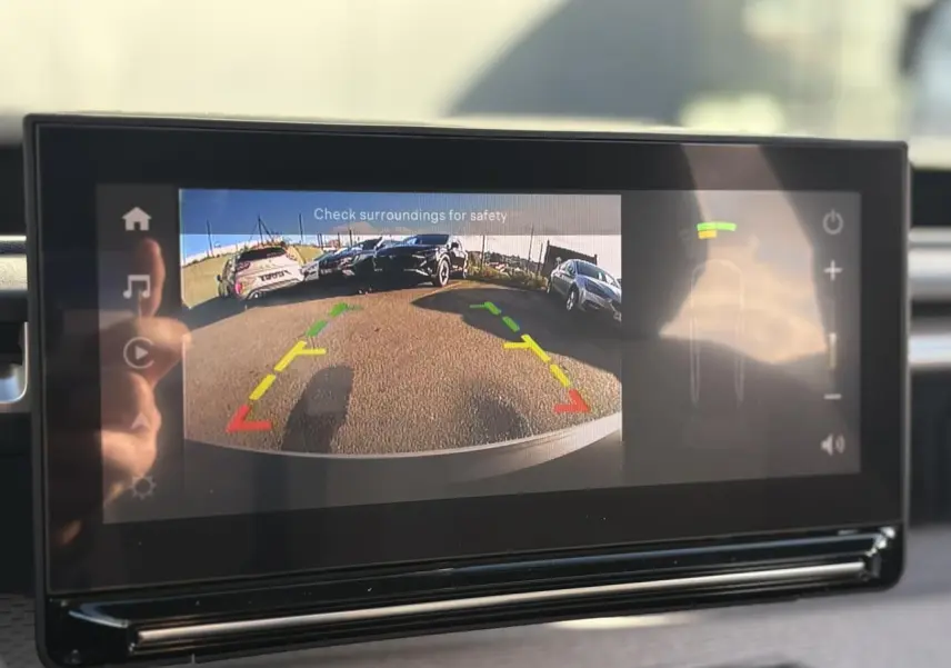 Écran tactile intérieur montrant la caméra de recul du Citroën C3 Aircross Hybrid rouge Elixir, vue arrière avec guidage coloré.