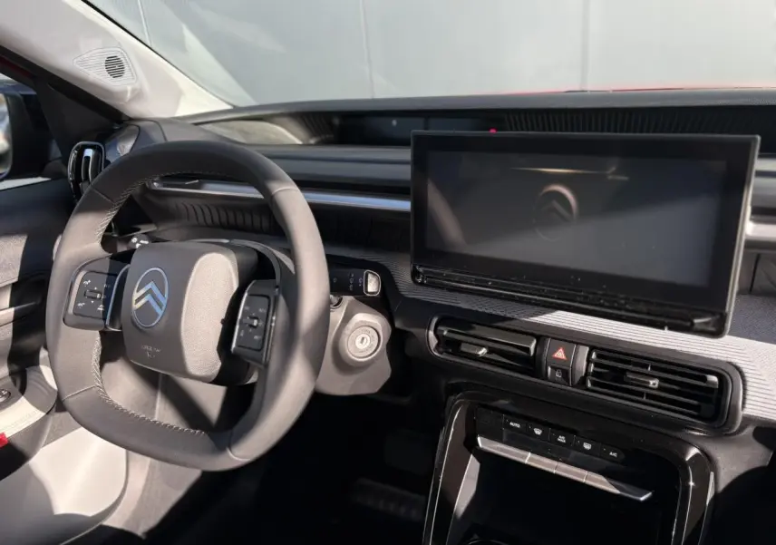 Vue intérieure côté conducteur du tableau de bord noir et gris du Citroën C3 Aircross Hybrid avec écran tactile central.