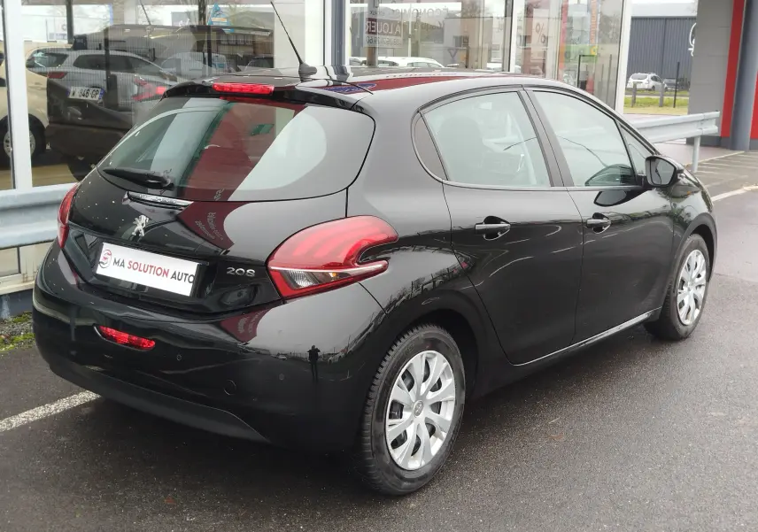 Vue 3/4 arrière droite d'une Peugeot 208 noire Perla Nera de 2019, avec feux arrière distinctifs et jantes argentées.