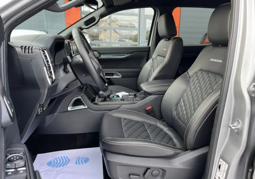 Vue intérieure côté gauche du Ford Ranger 2026 gris iconic, sièges cuir Platinum avec surpiqûres et volant multifonctions.