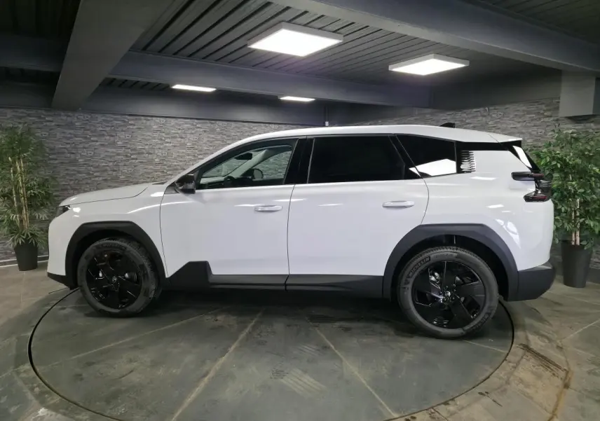 Vue latérale droite du Citroën C5 Aircross blanc avec jantes noires et détails noirs contrastants en intérieur.
