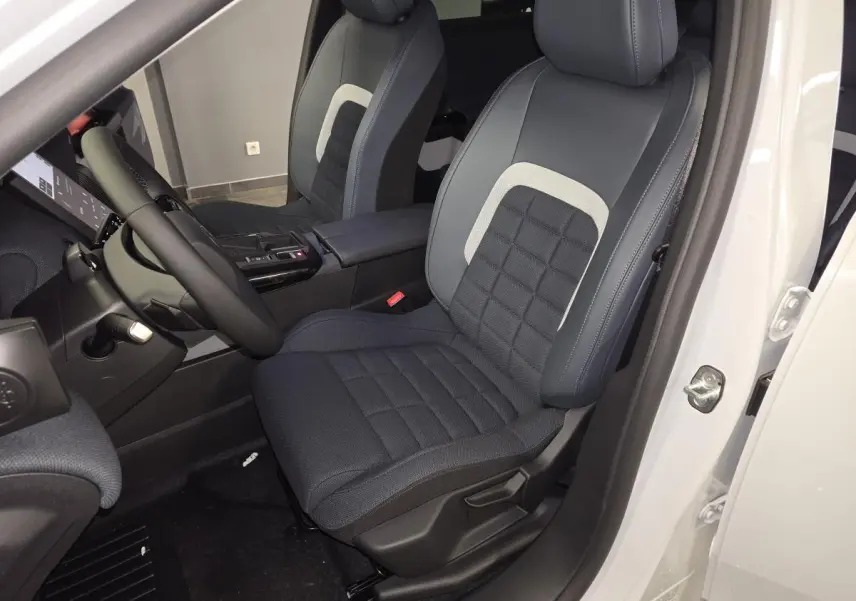 Vue intérieure côté conducteur du Citroën C5 Aircross blanc, siège tissu bleu avec insert clair et volant multifonctions.