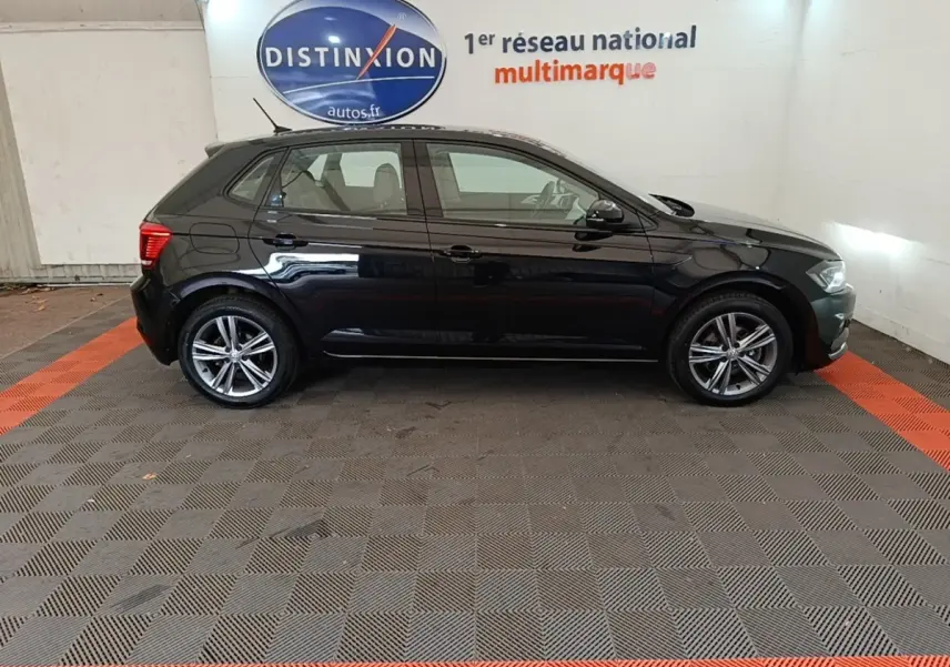 Profil droit d'une Volkswagen Polo noire 2020, avec jantes alliage et vitres teintées, en intérieur showroom.