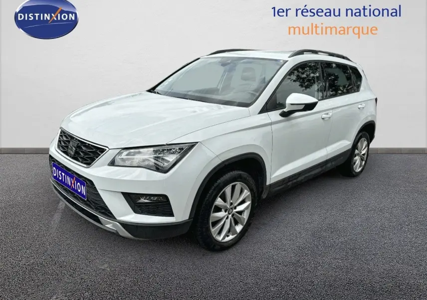 SEAT Ateca blanc en 3/4 avant droit, SUV compact avec jantes alliage et barres de toit noires visibles.