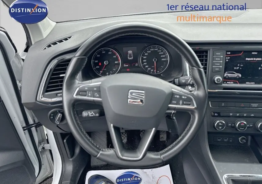 Vue intérieure centrée sur le volant du SEAT Ateca blanc 2018, avec tableau de bord et écran multimédia visibles.
