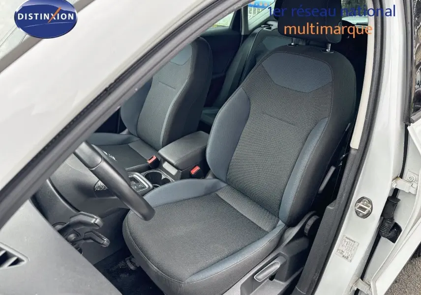Vue intérieure côté conducteur du SEAT Ateca blanc 2018, montrant le siège avant en tissu gris et bleu.