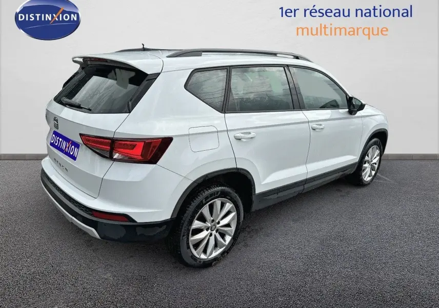 Vue 3/4 arrière droite d’un SUV SEAT Ateca blanc de 2018 avec jantes alliage et toit noir.