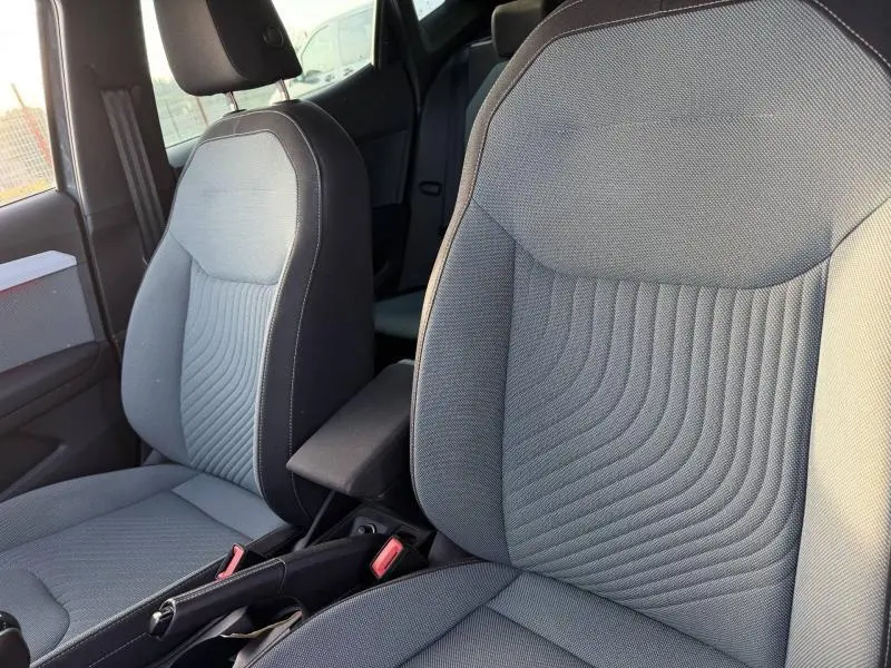 Gros plan sur les sièges avant gris de la SEAT Ibiza 2025, finition Xcellence, avec accoudoir central et coutures apparentes.