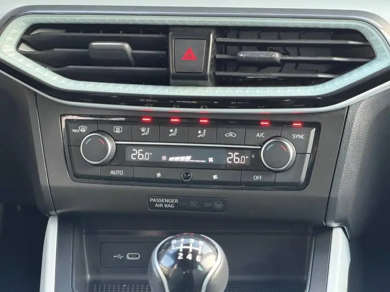 Gros plan sur la console centrale de la SEAT Ibiza 2025, avec climatisation digitale et levier de vitesse manuel visible.