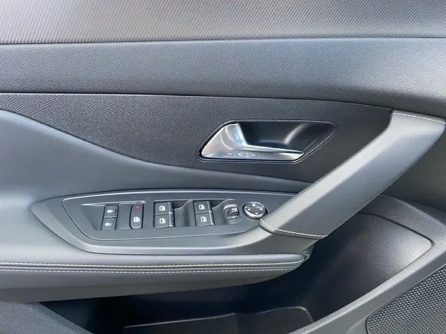Vue rapprochée de la porte côté gauche de la Peugeot 308 SW 2022 blanc nacré, avec commandes électriques et poignée noire.
