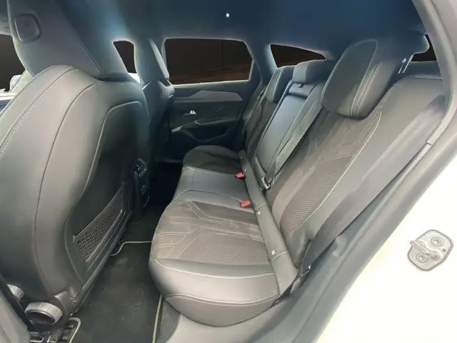 Vue intérieure arrière côté droit montrant les sièges arrière en tissu noir de la Peugeot 308 SW blanc nacré 2022.
