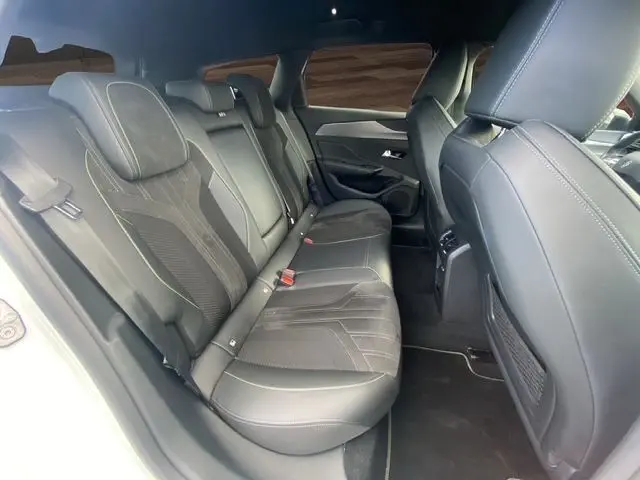 Vue intérieure côté gauche des sièges arrière en cuir noir de la Peugeot 308 SW blanc nacré, version 2022.