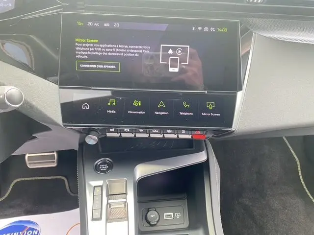 Vue intérieure centrée sur la console centrale et l'écran tactile de la Peugeot 308 SW blanc nacré, version 2022.