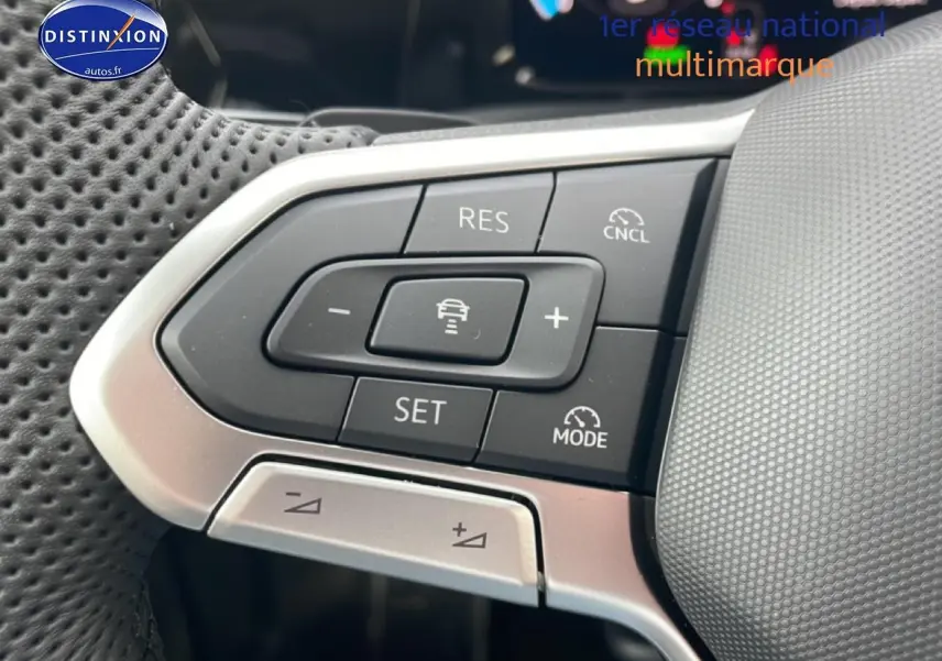 Gros plan sur les commandes du volant cuir perforé d'une Volkswagen Golf noire, version R-Line 2026.