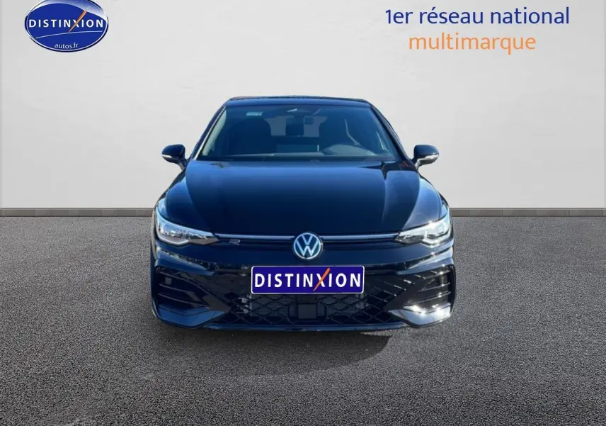 Vue de face d'une Volkswagen Golf noire 2026 avec calandre R-Line et phares LED allumés.