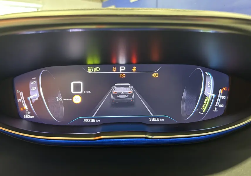 Tableau de bord numérique du Peugeot 3008 Hybrid gris, affichant la vitesse à 0 km/h et l'autonomie restante.