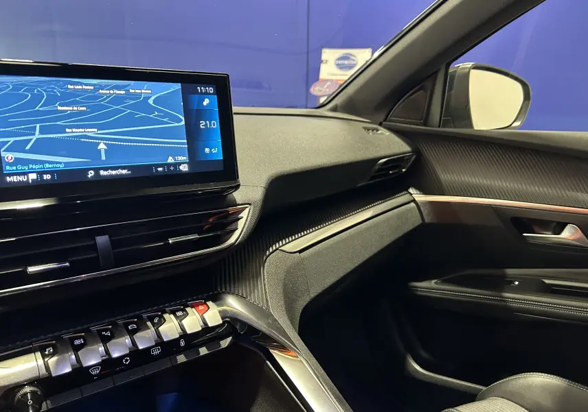 Vue intérieure côté passager du Peugeot 3008 gris 2024, avec écran tactile GPS et tableau de bord moderne.