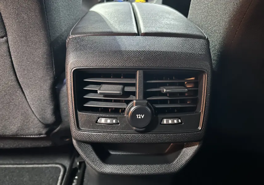 Détail des aérateurs arrière noirs avec prise 12V sur la console centrale d’un Peugeot 3008 gris.