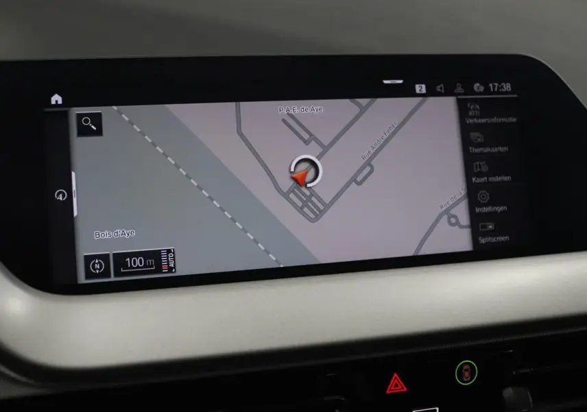 Écran GPS en gros plan dans l’habitacle d’une BMW Série 1 noire, affichant une carte routière détaillée.