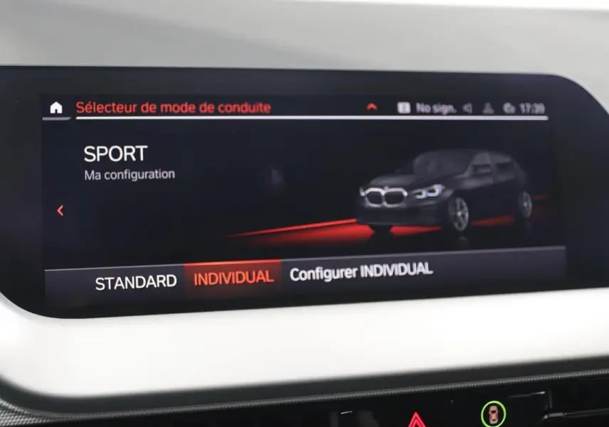 Écran intérieur montrant le mode de conduite SPORT avec illustration d'une BMW Série 1 noire en vue 3/4 avant.