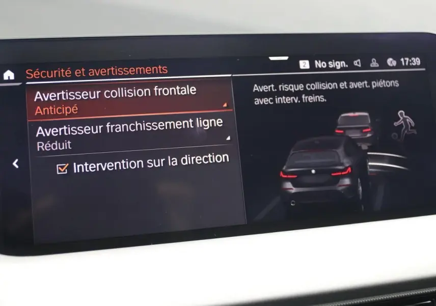 Écran intérieur de la BMW Série 1 116d noir montrant les réglages d'avertissement collision et franchissement de ligne.