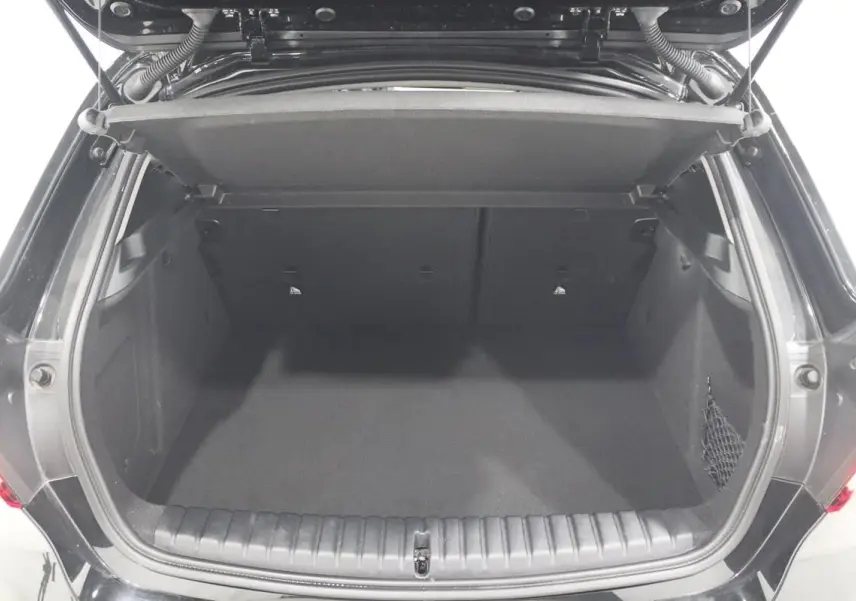 Coffre ouvert vu de l'arrière d'une BMW Série 1 noire 116d 2023, espace de chargement vide et propre.