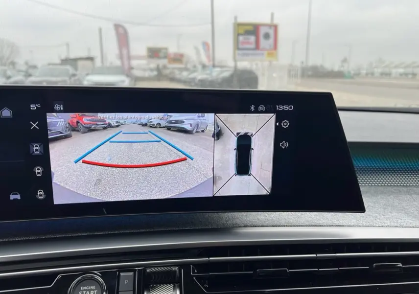 Affichage caméra de recul et vue 360° sur écran intérieur du Peugeot 5008 gris artense avec toit noir, tableau de bord visible.